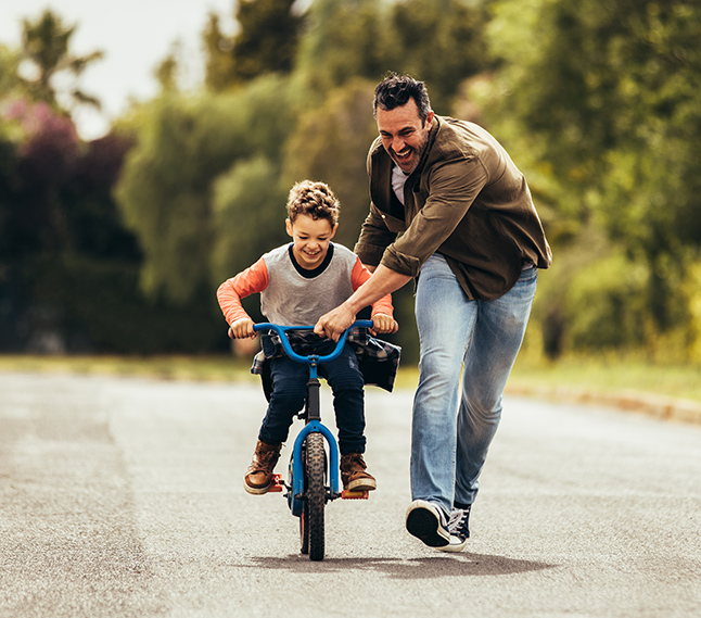 dad teaching son to ride bike parenting seminar character quest